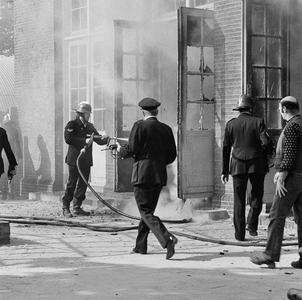 831217 Afbeelding van het blussen van een brand in de speelzaal van de kleuterschool Het Merelnest (Ondiep 63).